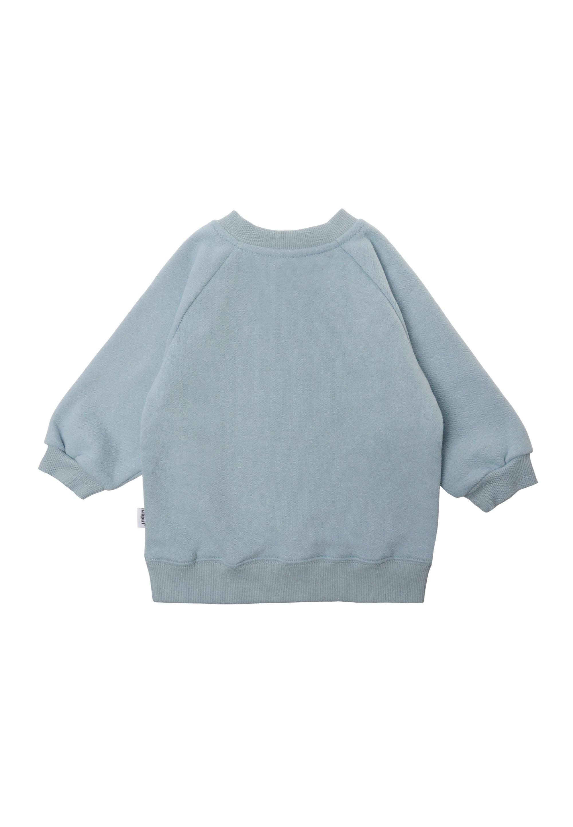 Lässiges Baby Sweatshirt Hellblau mit Dino-Motiv, weiche Baumwollmischung, elastische Bündchen und Druckknöpfe für einfaches An- und Ausziehen.