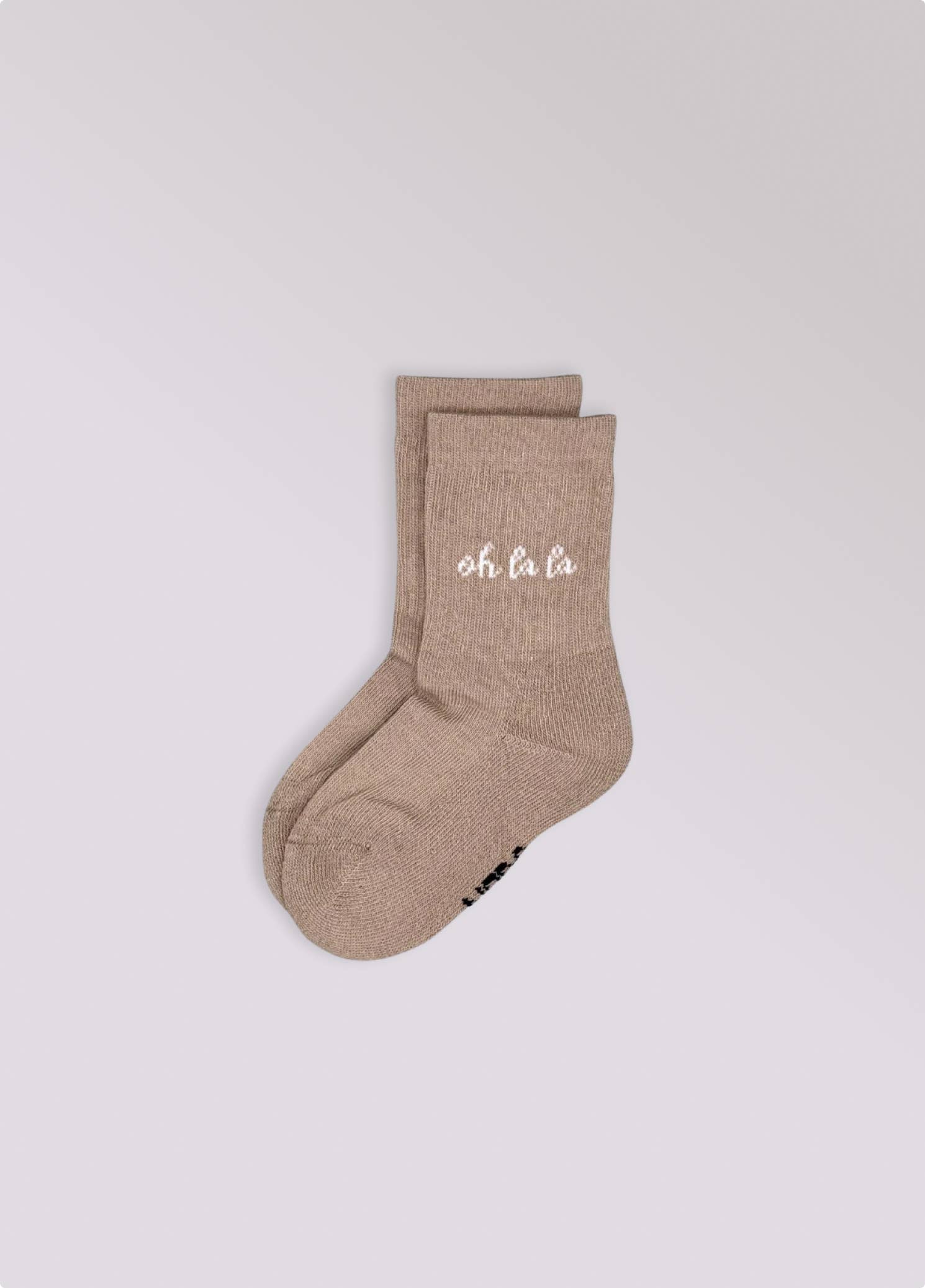 Kinder-Socken in Beige von No Bad Days Club mit eingewebtem „oh la la“-Schriftzug, nahtfrei, extra verstärkt unter dem Fuß, nachhaltig produziert in Portugal.