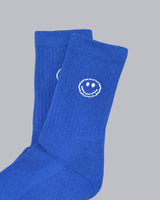 Kinder-Socken in Blau von No Bad Days Club mit eingewebtem Smiley, nahtfrei, extra verstärkt unter dem Fuß, nachhaltig produziert in Portugal.