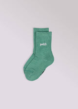 Kinder-Socken in Grün von No Bad Days Club mit eingewebtem „petit“-Schriftzug, nahtfrei, extra verstärkt unter dem Fuß, nachhaltig produziert in Portugal.