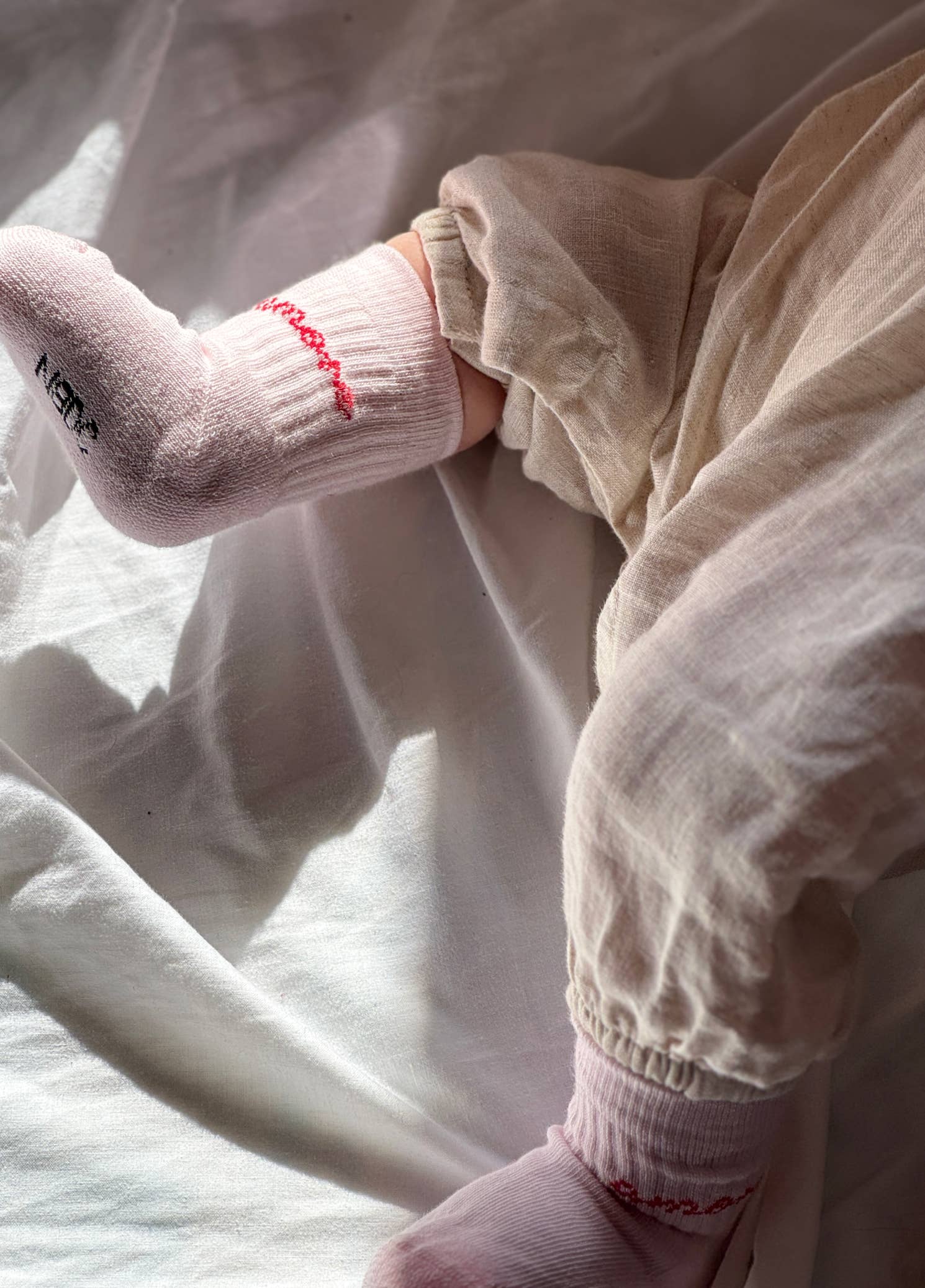 Kinder-Socken in Rosa von No Bad Days Club mit eingewebtem „amore“-Schriftzug, nahtfrei, extra verstärkt unter dem Fuß, nachhaltig produziert in Portugal.