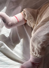 Kinder-Socken in Rosa von No Bad Days Club mit eingewebtem „amore“-Schriftzug, nahtfrei, extra verstärkt unter dem Fuß, nachhaltig produziert in Portugal.