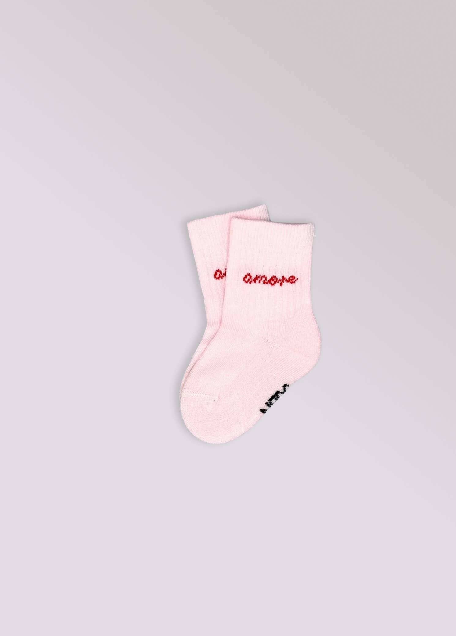 Kinder-Socken in Rosa von No Bad Days Club mit eingewebtem „amore“-Schriftzug, nahtfrei, extra verstärkt unter dem Fuß, nachhaltig produziert in Portugal.