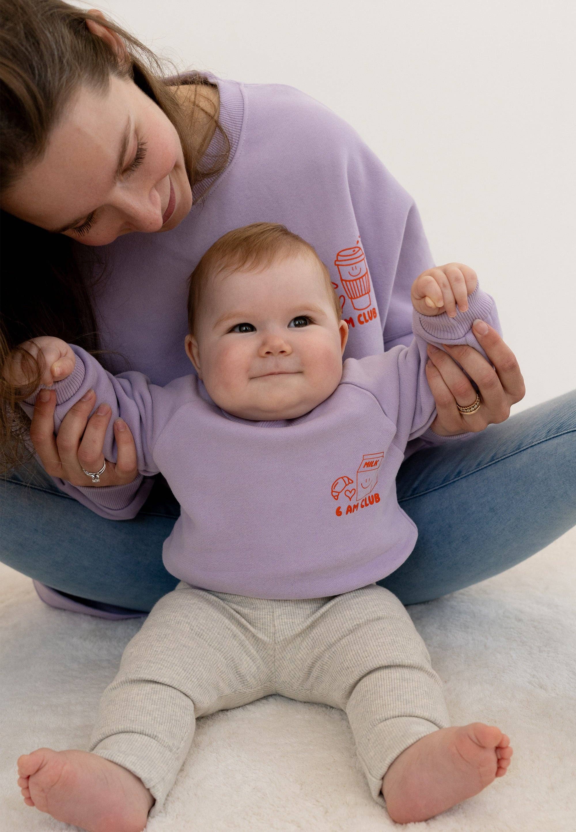 Fliederfarbenes Kinder-Sweatshirt 6 am Club Mini & Me Edition mit Print aus Milchtüte, Croissant, Herzchen und orangem Schriftzug.
